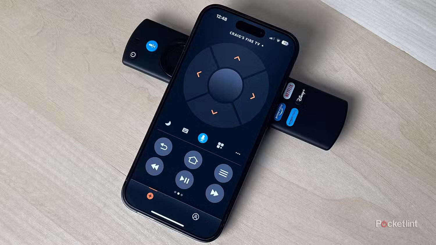 L'app Fire TV su un iPhone accanto a un telecomando Alexa Voice.